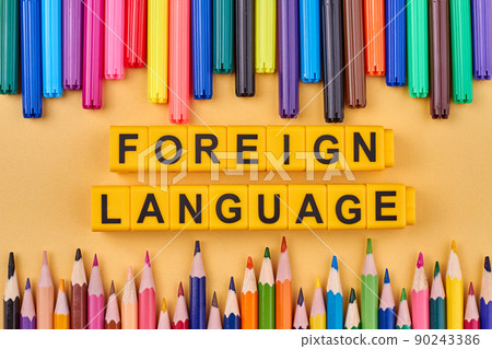 Frame from colorful pencils and inscription FOREIGHN LANGUAGE written on plastic cubes. 90243386