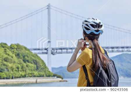 在島波海道上享受騎自行車的當地婦女 在島波海道上享受騎自行車的當地婦女 90243506