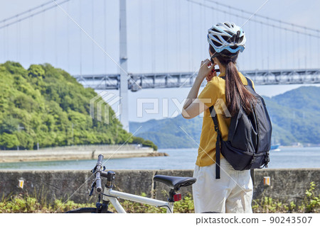 A local woman enjoying cycling on the Shimanami Kaido 90243507
