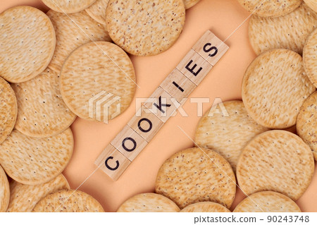 Close up of many delicious round biscuits. Wooden cubes with written text cookies. 90243748