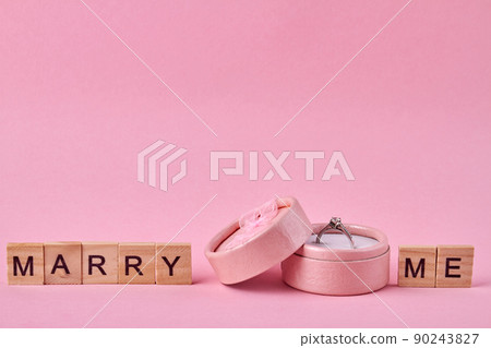Marry me inscription and gift box with engagement ring. 90243827