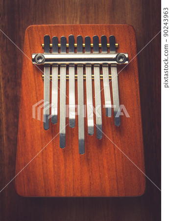 Traditional wooden kalimba on a wooden background Traditional wooden kalimba on a wooden background 90243963