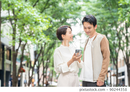 A smiling couple having a date (going out, going out, shopping, couples, smartphones, apps) A smiling couple having a date (going out, going out, shopping, couples, smartphones, apps) 90244358