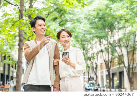 A smiling couple having a date (going out, going out, shopping, couples, smartphones, apps) 90244367