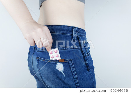 Tablets for pain during menstruation. Pain during menses. The concept of critical days for a woman. The girl stands on a white background and holds medicines for pain in her hands. Painkillers Tablets for pain during menstruation. Pain during menses. The concept of critical days for a woman. The girl stands on a white background and holds medicines for pain in her hands. Painkillers 90244656