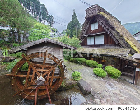 Gero Onsen Gassho Village Waterwheel and thatched roof building 90244780