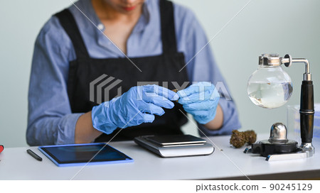 Chemist researching and examining hemp oil in laboratory. Herbal alternative medicine, cbd oil concept Chemist researching and examining hemp oil in laboratory. Herbal alternative medicine, cbd oil concept 90245129