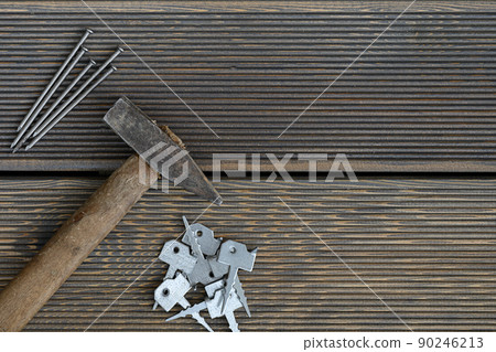 Carpentry tools hammer and hobnail lie for assembly on larch floor. 90246213