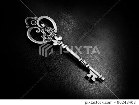 Old bronze key on a dark background 90248408