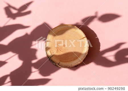 Woodcut on a trendy pink background with shadows of flowers. Natural mockup. A wooden platform with shades for natural cosmetics or products presentation. Wooden tray. Top view, flat lay Woodcut on a trendy pink background with shadows of flowers. Natural mockup. A wooden platform with shades for natural cosmetics or products presentation. Wooden tray. Top view, flat lay 90249298