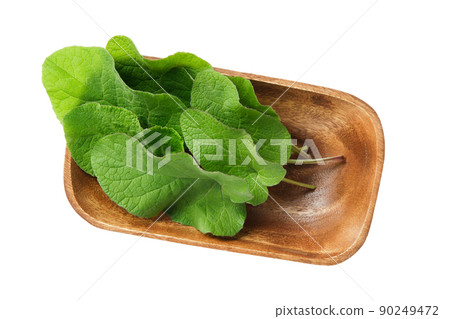 Wooden bowl of green Burdock leaves, isolated on white. Top view. Wooden bowl of green Burdock leaves, isolated on white. Top view. 90249472