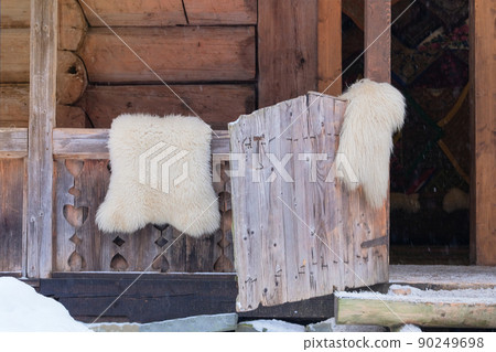 Tanned sheepskins rugs hang on a fence at a wood house in countryside. Travel, tourism and environment concept. Tanned sheepskins rugs hang on a fence at a wood house in countryside. Travel, tourism and environment concept. 90249698