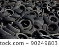 Landfill with old tires and tyres for recycling. Reuse of the waste rubber tyres. Disposal of waste tires. Worn out wheels for recycling. Regenerated tire rubber produced. 90249803