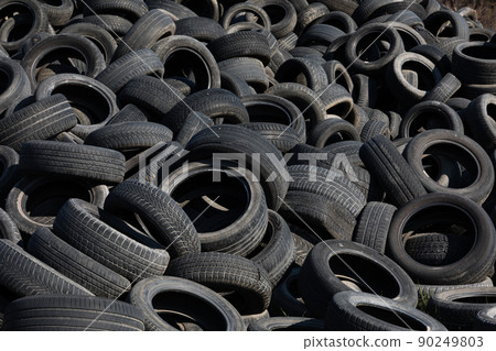 Landfill with old tires and tyres for recycling. Reuse of the waste rubber tyres. Disposal of waste tires. Worn out wheels for recycling. Regenerated tire rubber produced. 90249803