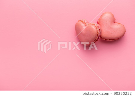Heart shaped Sweet macarons on pink background. 90250232