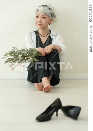 脫下她的高跟鞋的時興的資深婦女 90251836