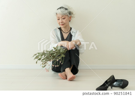 Fashionable senior woman taking off her heels Fashionable senior woman taking off her heels 90251841