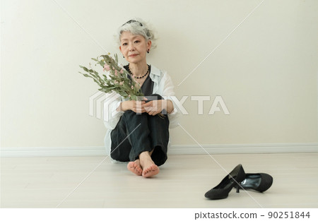 Fashionable senior woman taking off her heels Fashionable senior woman taking off her heels 90251844