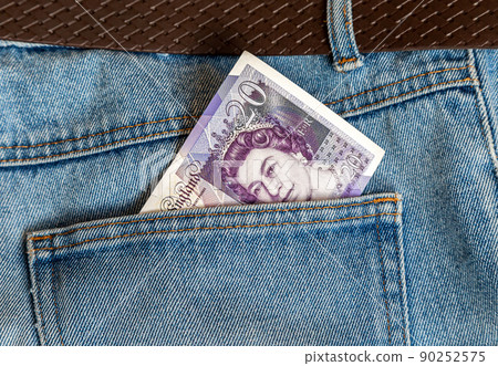 Banknote of twenty england pounds sticking out of the jeans pocket Banknote of twenty england pounds sticking out of the jeans pocket 90252575
