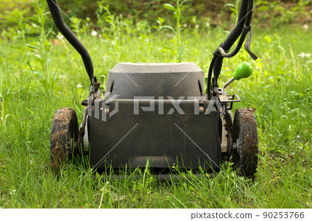 Low Angle Close up lawnmower ready to be cutting long grass or illustrating concept of helping bees 90253766