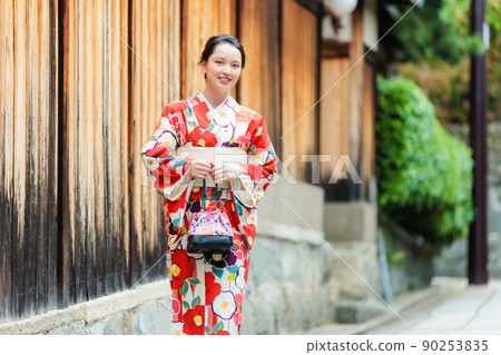 一個穿著和服的年輕女子在京都的鵝卵石上行走 90253835