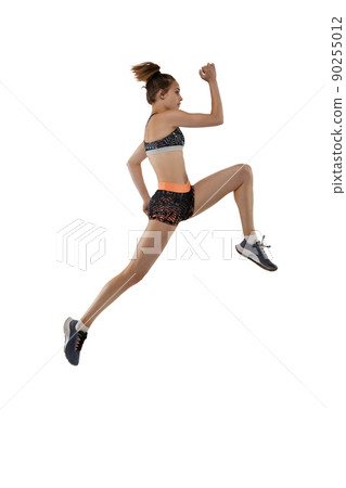 Long jump technique. Studio shot of professional female athlete in sports uniform jumping isolated on white background. Concept of sport, action, motion, speed. Long jump technique. Studio shot of professional female athlete in sports uniform jumping isolated on white background. Concept of sport, action, motion, speed. 90255012