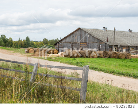 Old wooden hayloft or haymow. Rural landscape with village road and barn for hay. Agricultural building in countryside. Old wooden hayloft or haymow. Rural landscape with village road and barn for hay. Agricultural building in countryside. 90255828
