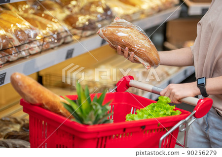 Modern young woman with long hair choosing bread in grocery store in morning, copy space Modern young woman with long hair choosing bread in grocery store in morning, copy space 90256279