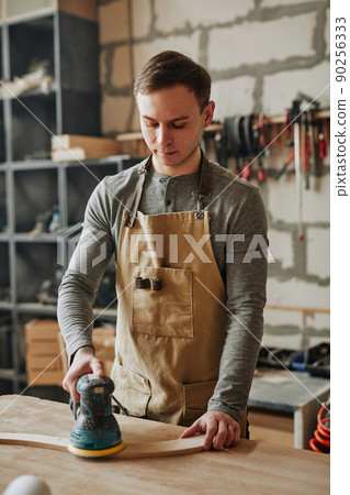 Young Man Working with Wood in Shop Young Man Working with Wood in Shop 90256333