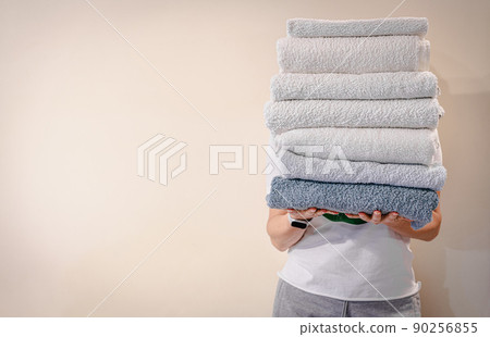 Woman holding a stack of towels 90256855