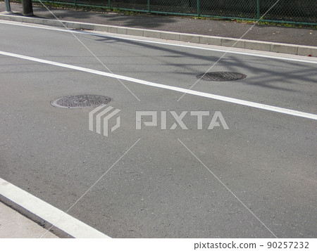 一條單車道道路，中心線為純白色，帶有兩個檢修孔 90257232