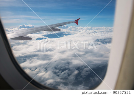 Cloudscape view from window of flying airplane Cloudscape view from window of flying airplane 90257531
