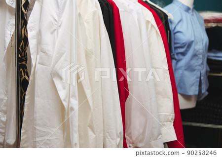 Details of women's clothes hanging on hangers in clothing design and tailoring atelier of fashion boutique Details of women's clothes hanging on hangers in clothing design and tailoring atelier of fashion boutique 90258246