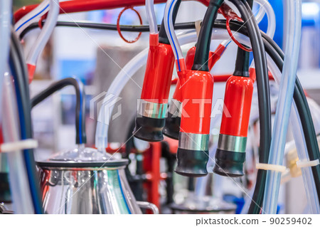 Teat cups of automated cow milking suction machine at exhibition: close up Teat cups of automated cow milking suction machine at exhibition: close up 90259402