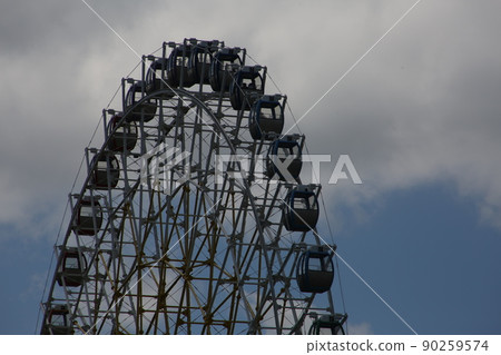 Ferris wheel. Amusement park with a big wheel for an overview of the city. Steel metal structure with cabins for people Ferris wheel. Amusement park with a big wheel for an overview of the city. Steel metal structure with cabins for people 90259574