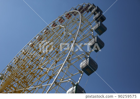 Ferris wheel. Amusement park with a big wheel for an overview of the city. Steel metal structure with cabins for people Ferris wheel. Amusement park with a big wheel for an overview of the city. Steel metal structure with cabins for people 90259575