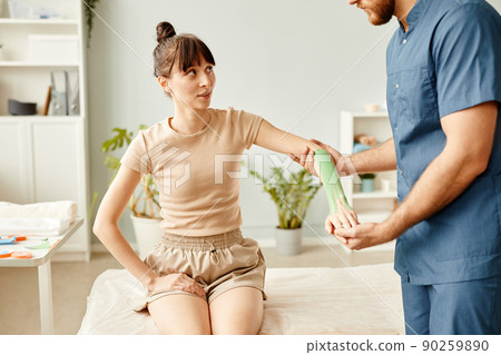 Young Woman using Physio Tapes in Therapy Young Woman using Physio Tapes in Therapy 90259890