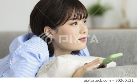 Young woman smartphone thinking while looking at a smartphone 90260121
