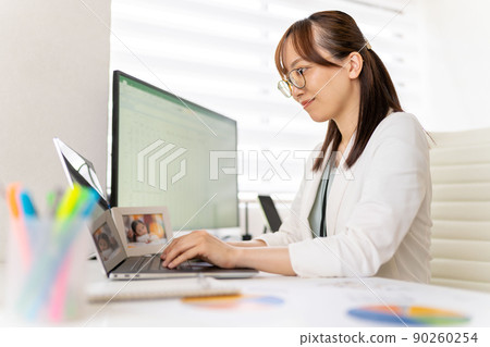 一位年輕女工程師在辦公桌上裝飾孩子照片的全家福 一位年輕女工程師在辦公桌上裝飾孩子照片的全家福 90260254