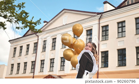 Happy Russian schoolgirl on the last day of school with balloons. 90260796
