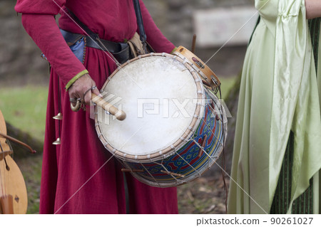 Medieval minstrel playing drum 90261027