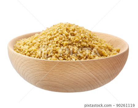 Raw bulgur in a wooden bowl isolated on white background. Raw bulgur in a wooden bowl isolated on white background. 90261119