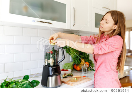 Woman preparing tasty green smoothie in kitchen 90261954