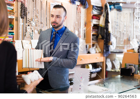 seller offering colored necklaces and pendants 90264563