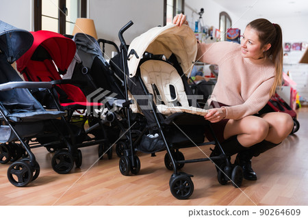 woman choosing carriage for kids woman choosing carriage for kids 90264609