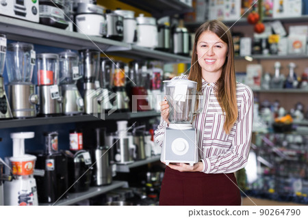 Girl seller offering blender in domestic appliances section Girl seller offering blender in domestic appliances section 90264790