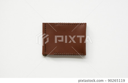 Orange men's money clip handmade leather wallet. Empty money clip wallet with a two pockets for cards lies on a white table. Selective focus, copy space. 90265119