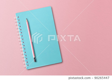 Blue notebook with pencils placed on pink background. 90265447