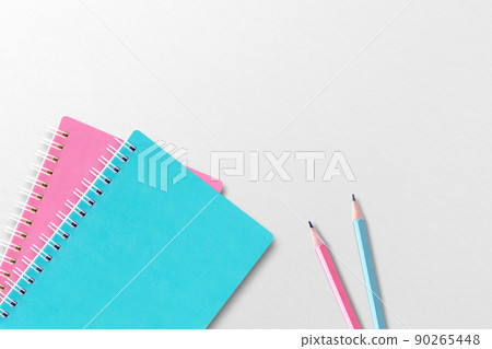 Blue and pink notebooks placed on white paper. Two pencils. 90265448