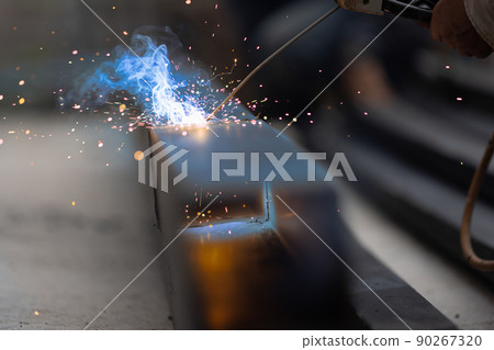 worker welding steel pipe in construction site 90267320